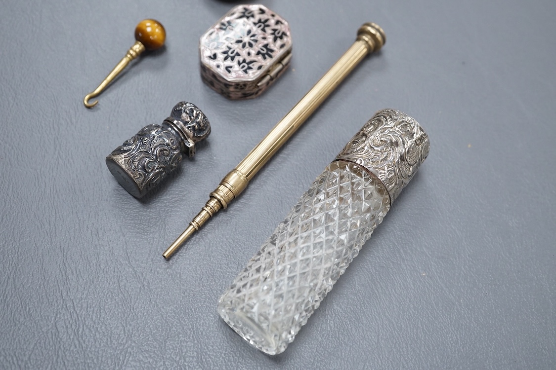 A 19th century Viennese gilt white metal and enamel circular vinaigrette, makers mark J.i.G, diameter 29mm, together with two late 19th century silver mounted senet bottles, a white metal and enamel pill box, a propellin